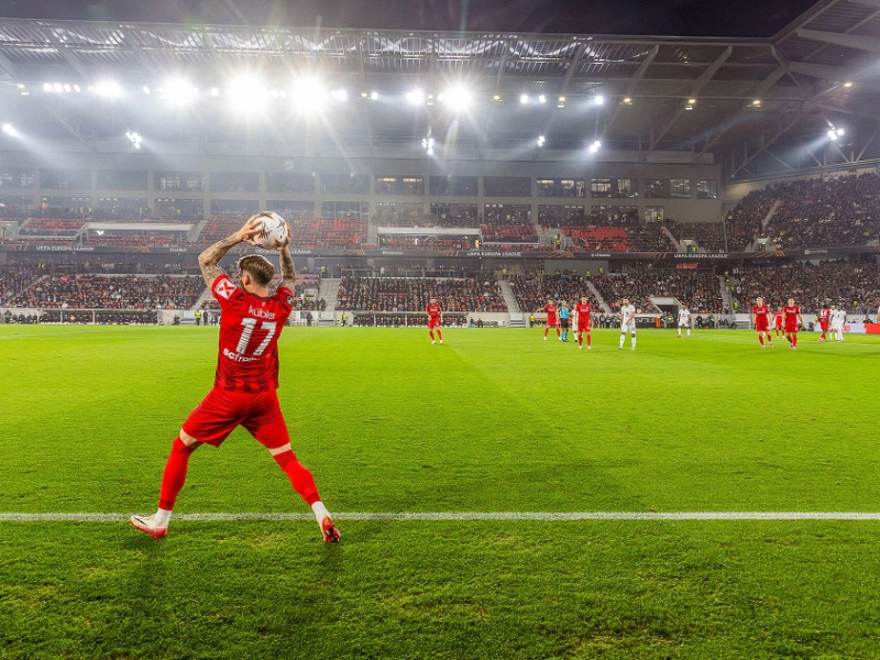 Der SC-Freiburg Spieler Kübler im roten Trikot macht einen Einwurf von der Seitenlinie.
