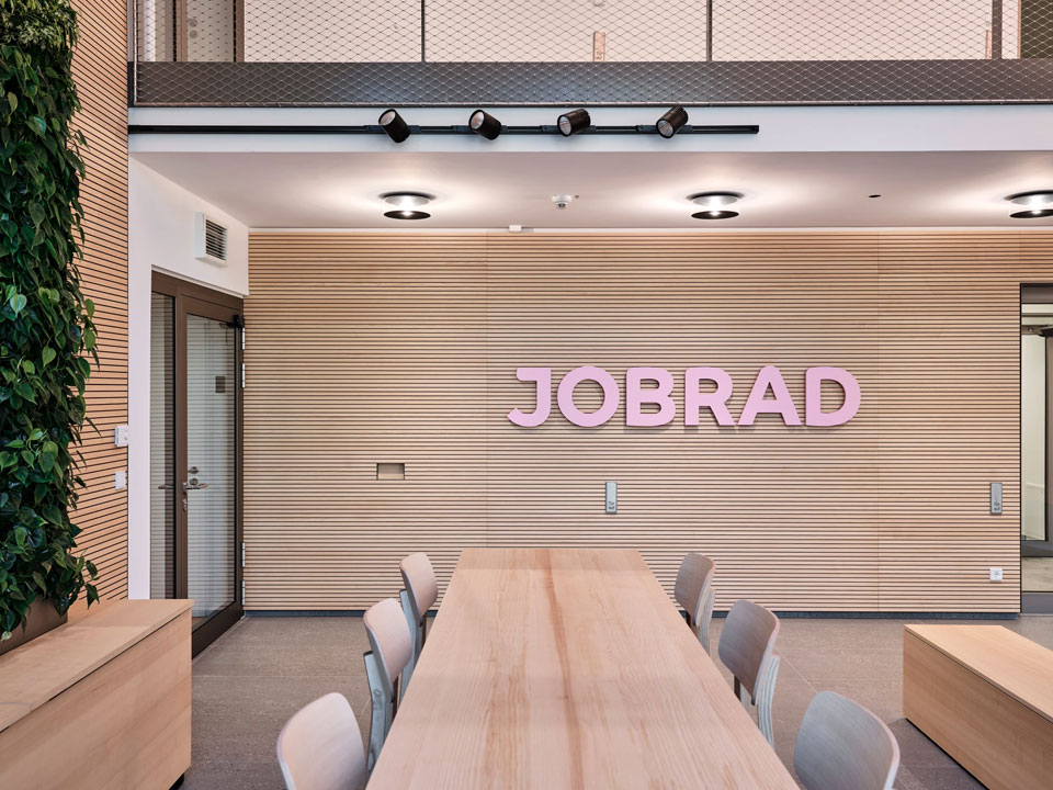 jobrad foyer holzwand mit rosa logo